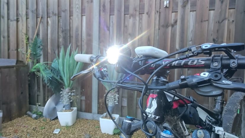 Mountainbike met brandende Hilox LED-koplamp op het stuur
